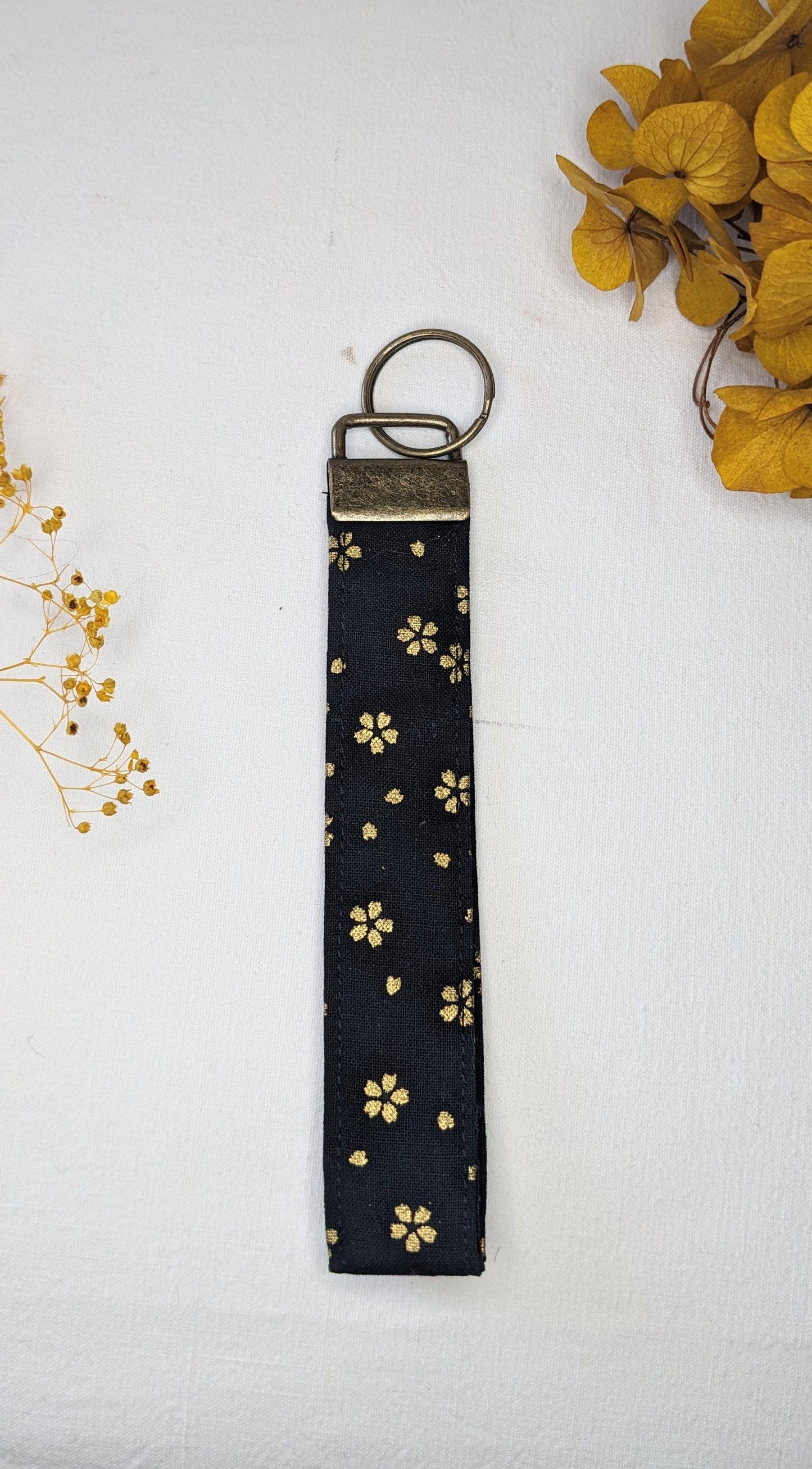 Porte-clés noir/fleurs dorées